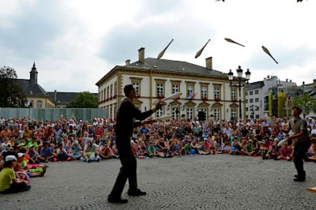 Zwei Männer werfen sich Kegel zu. 