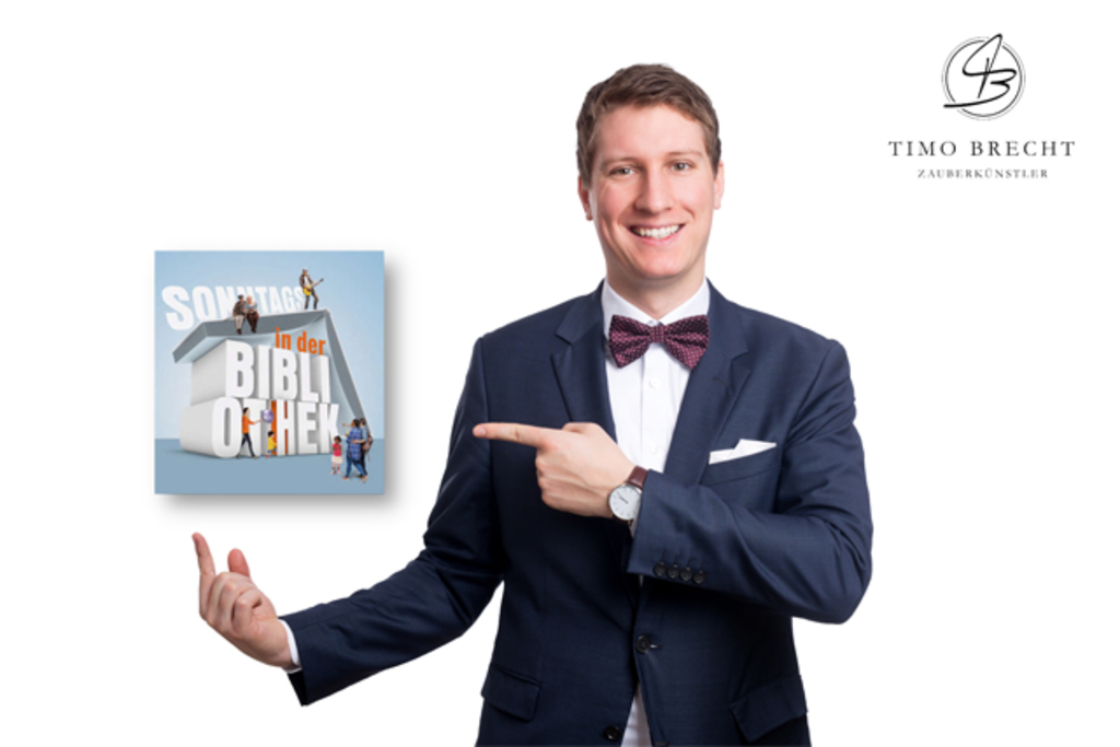 Timo Brecht zeigt auf Logo Sonntags in der Bibliothek