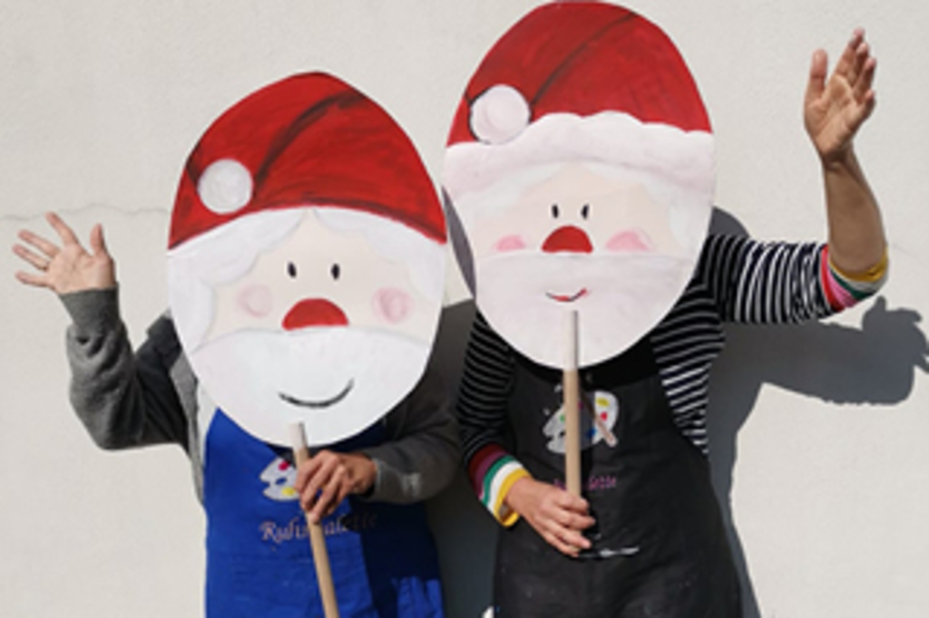 Zwei Menschen, die sich ein Nikolausgesicht vor ihr Gesicht halten