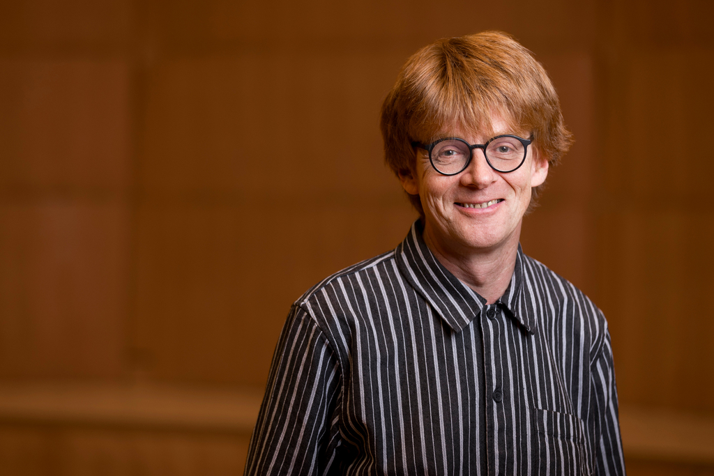 Porträit des Musikers und Komponisten Enno Poppe in gestreiftem Hemd mit schwarzer Brille