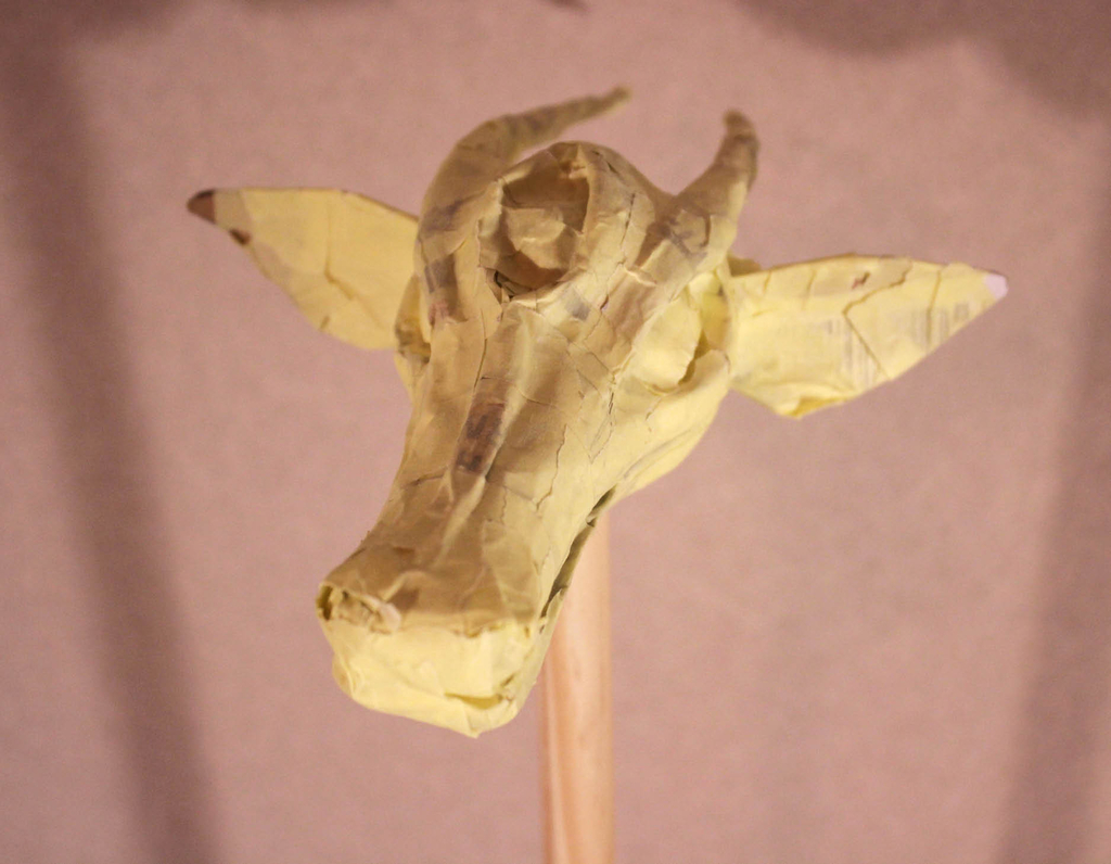 Abbildung eines mit Kreppband modellierten Kopfes eines Drachen, auf einen Stab montiert