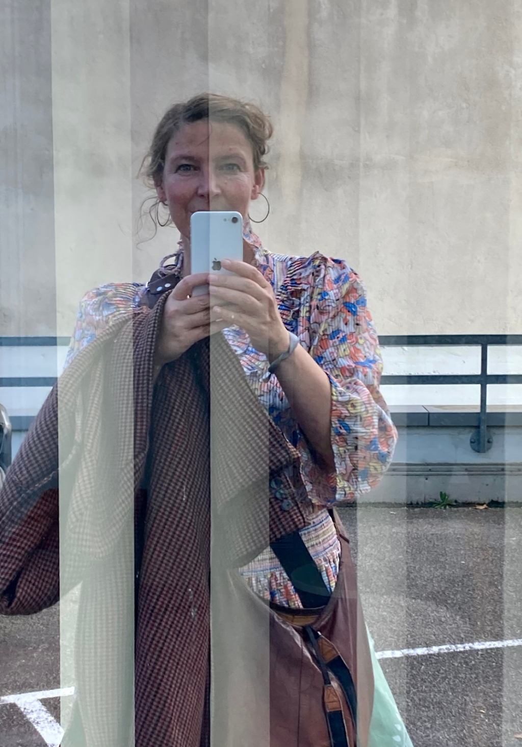 Selfie der Autorin in einer verspiegelten Fensterscheibe, aufgenommen mit ihrem Handy