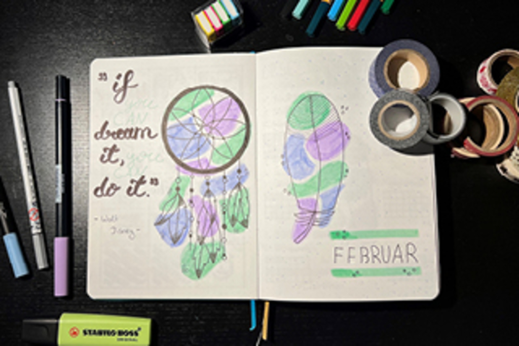 Aufgeschlagenes Bullet Journal mit Stiften, Klebestreifen und Markern