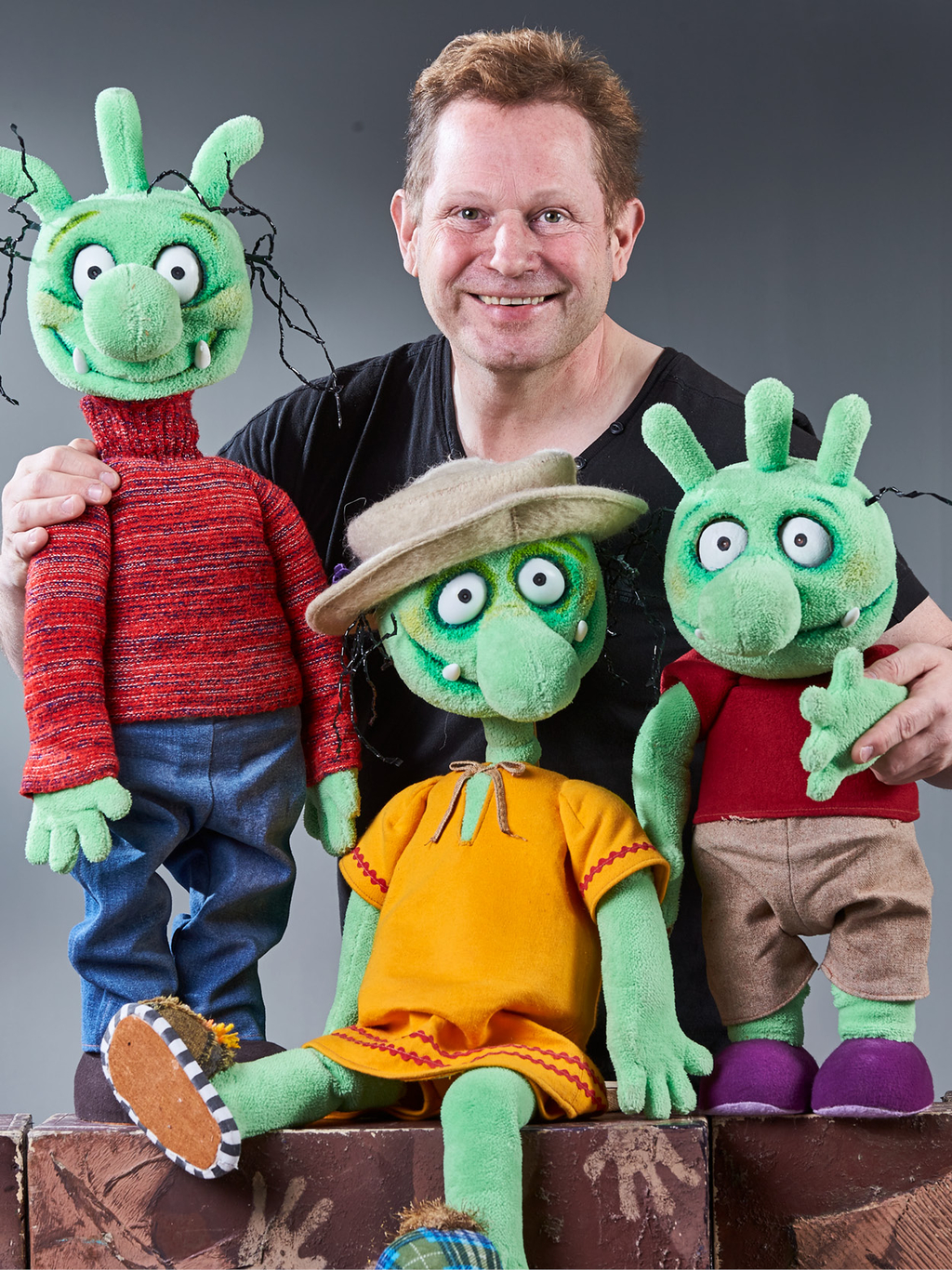 Andreas Blaschke mit drei grünen Olchi Figuren