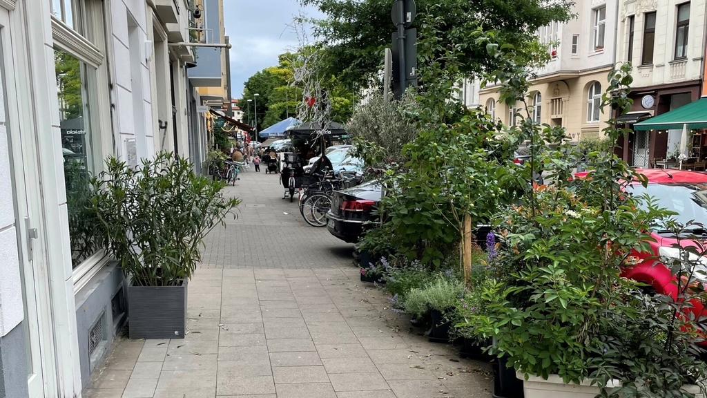 bepflanzte Blumenkübel auf dem Bürgersteig an der Alteburger Straße, Link auf Köln - FUSS e.V.