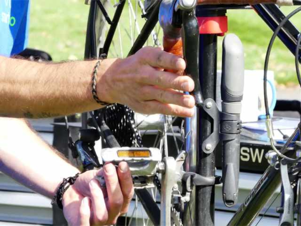 Foto von Händen eines Mechanikers, der ein Fahrrad repariert.