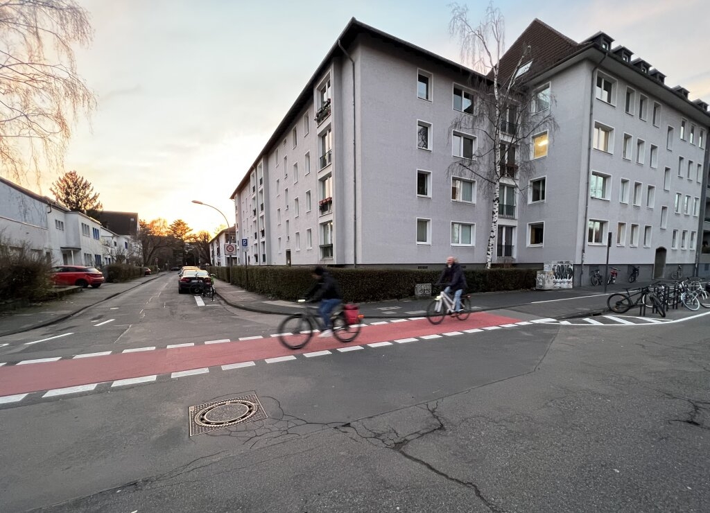 Zwei Radfahrende auf neuer, roter Fahrradfurt an der Einmündung Repgowstraße auf der Universitätsstraße