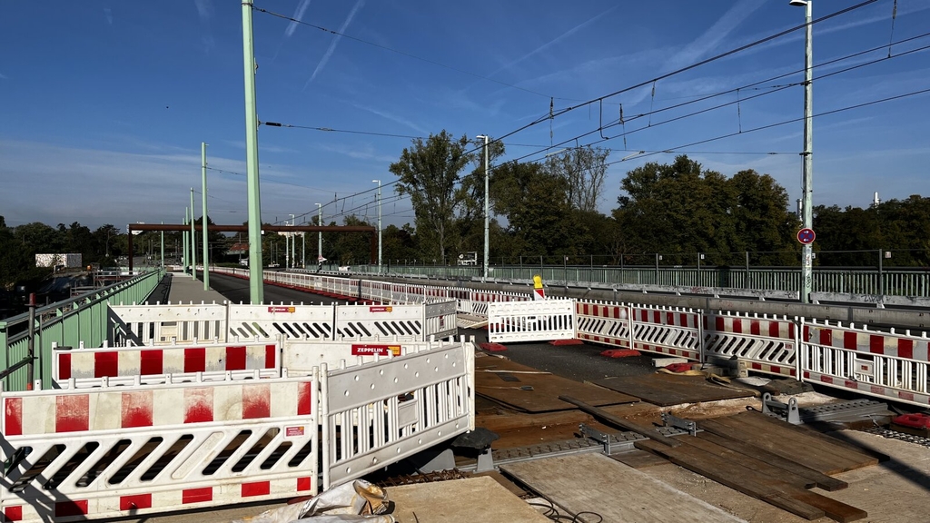 Zu sehen sind rot-weiße Baugitter auf der Mülheimer Brücke im Bereich der Flutbrücke.