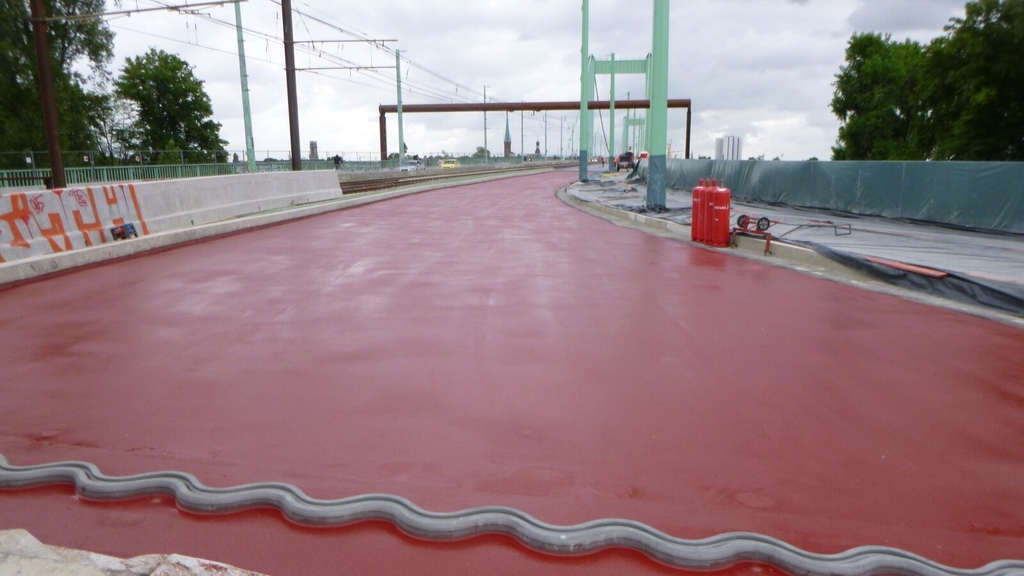 Abdichtungsarbeiten auf der Fahrbahn und Stahlbetonarbeiten im Bereich des Geh-/Radwegs auf dem südlichen Teil der Deichbrücke an der Mülheimer Brücke.