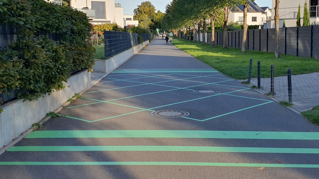neue grüne Markierungen an einer Straßeneinmündung mit einer wieder entfernbaren Folie