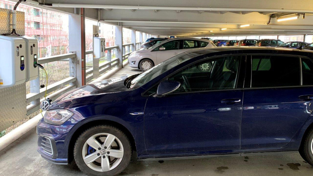 E-Ladesäule im Parkhaus an der LANXESS arena, an der gerade ein blaues Auto geladen wird.