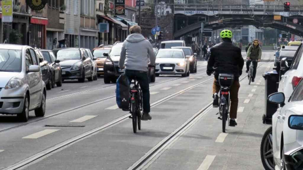 Radfahrende befahren eine Straße mit Stadtbahnschienen
