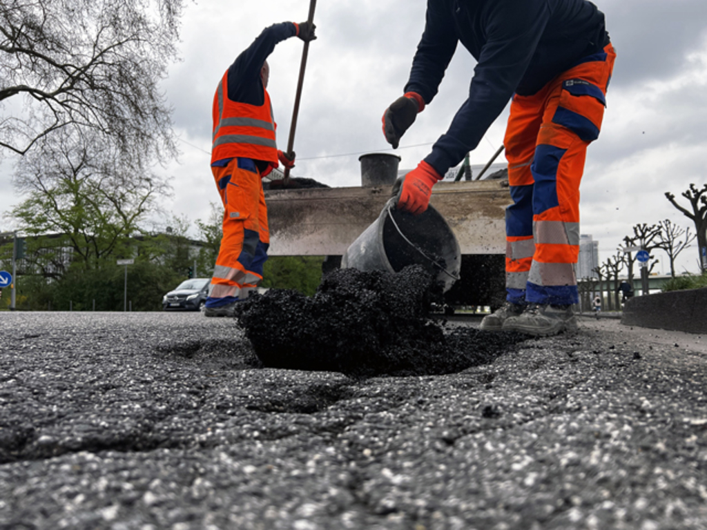 Mitarbeitende des Bauhofs beseitigen ein Schlagloch