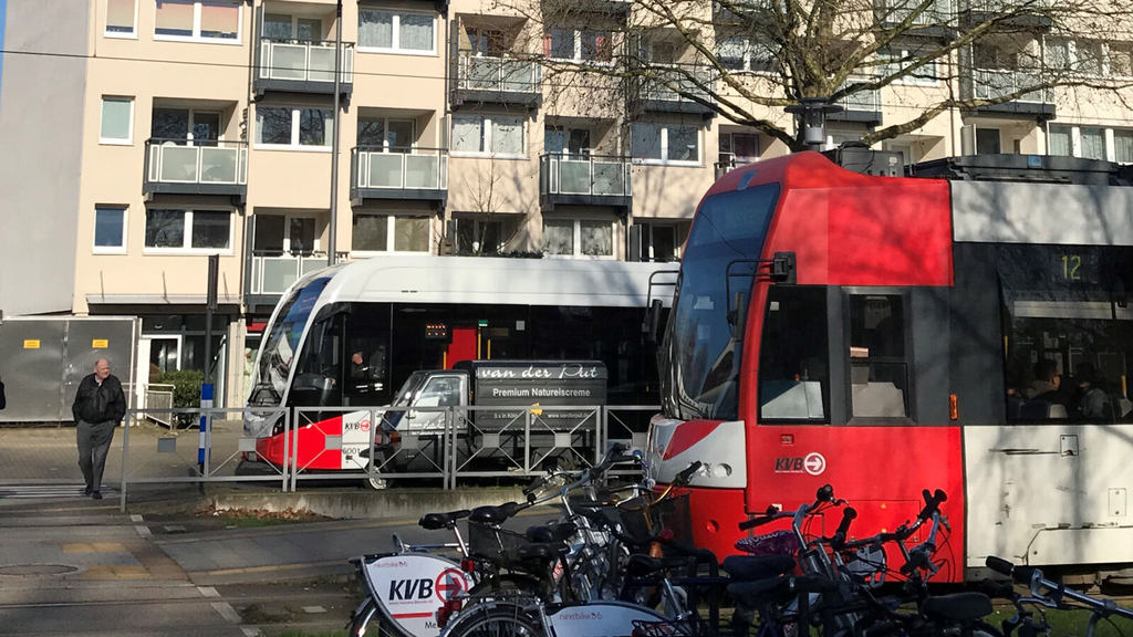 Zwei Stadtbahnen an einer Haltestelle. Im Vordergrund abgestellte Fahrräder.