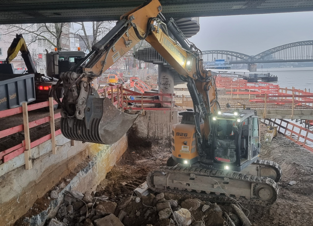 Zu sehen ist ein Bagger unter der Deutzer Brücke