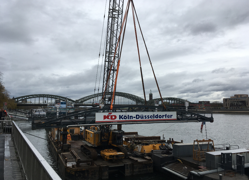 Zu sehen ist der Abbau der Landebrücke der Köln-Düsseldorfer Deutsche Rheinschiffahrt GmbH mit einem Kran.