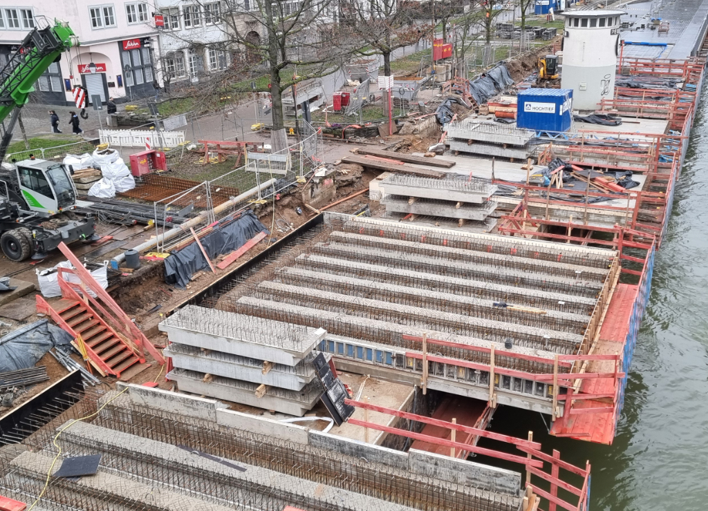 Zu sehen ist eine Luftaufnahme der Kragplatte am Altstadtufer. Neben dem Baufeld steht ein Baustellenfahrzeug.