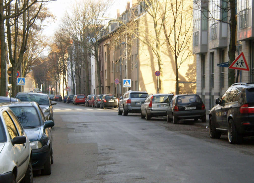 Ansicht der Takustraße, rechts und links parken Kraftfahrzeuge