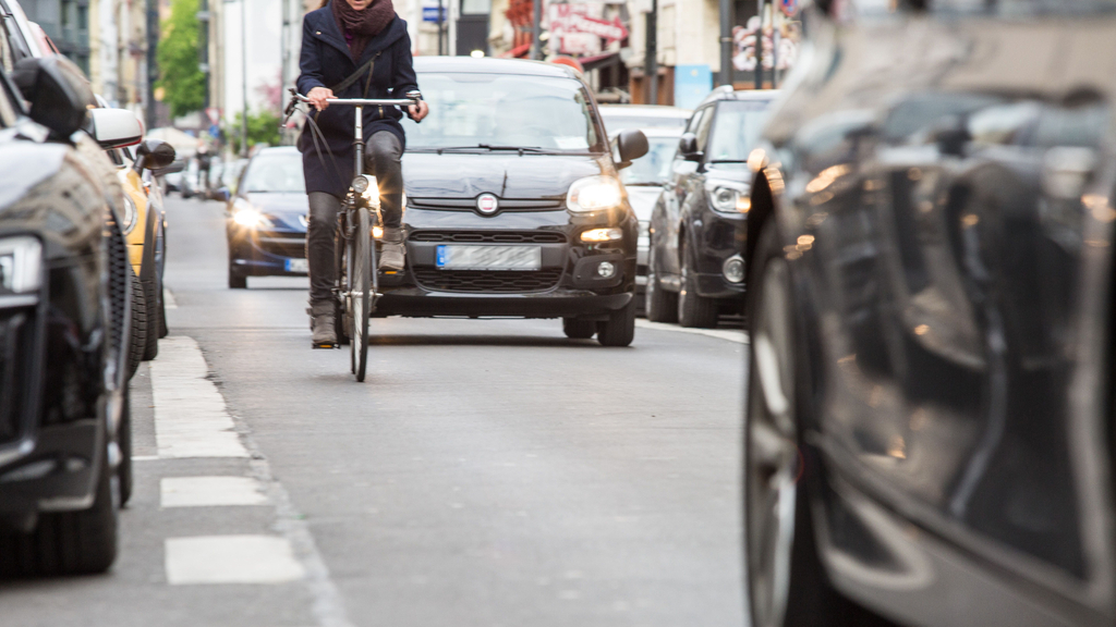 Radfahrerin fährt den Friesenwall entlang, hinter ihr fahren Autos