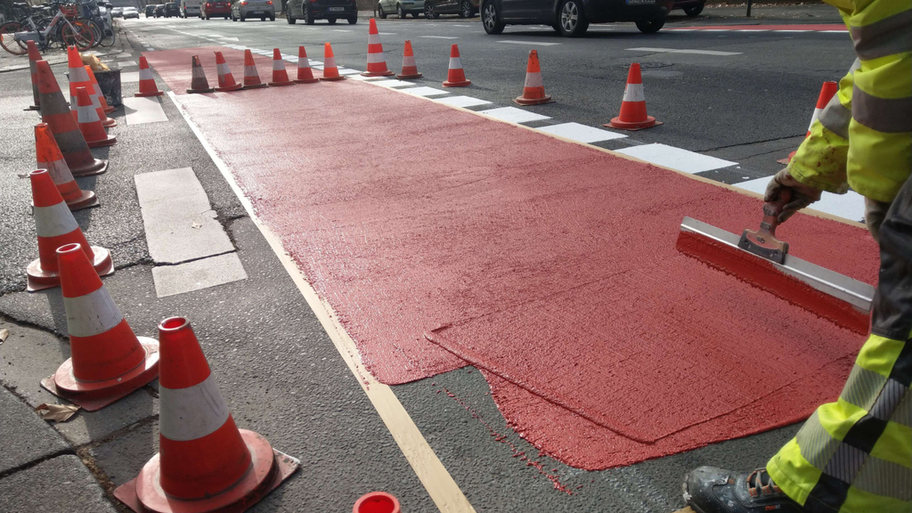 Auf der Vorgebirgstraße wird mit roter Farbe ein neuer Radfahrstreifen markiert
