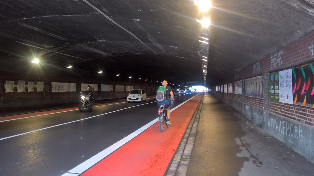 Radfahrer fährt auf dem rot eingefärbten Radfahrstreifen im Eisenbahntunnel Klettenberggürtel