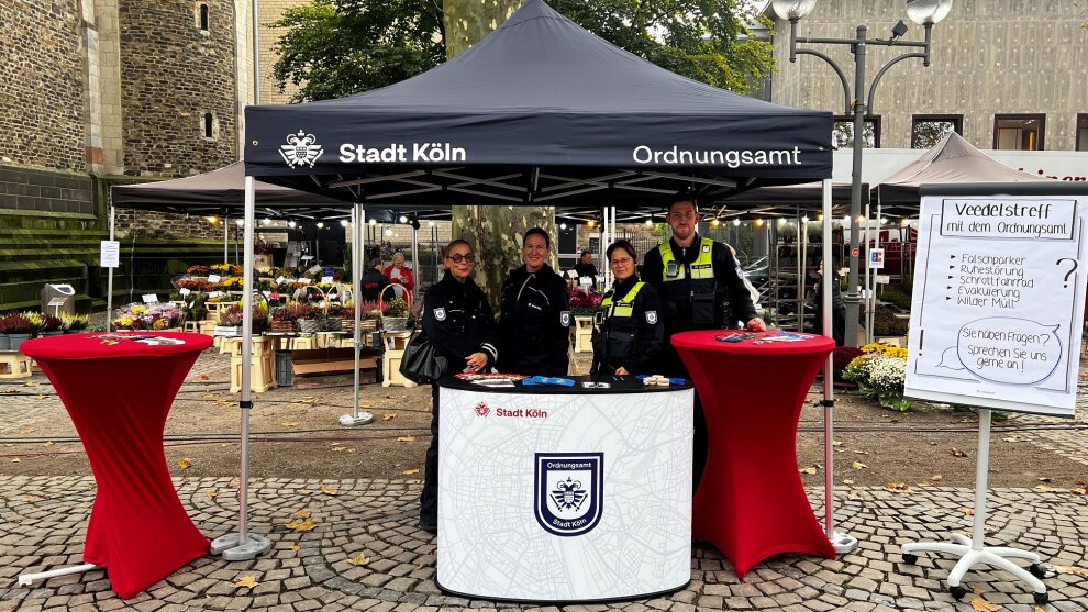 Vier Mitarbeitende des Ordnungsamtes an einem Infostand