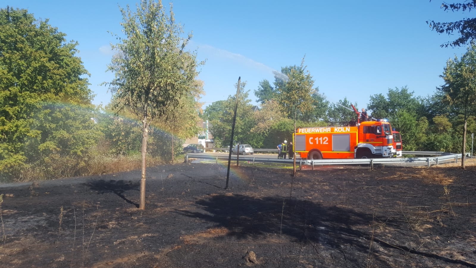 Vegetationsbrand in Roggendorf/Thenhoven. Im Hintergrund ist ein Feuerwehrauto von dem aus ein Vegetationsbrand gelöscht wird.