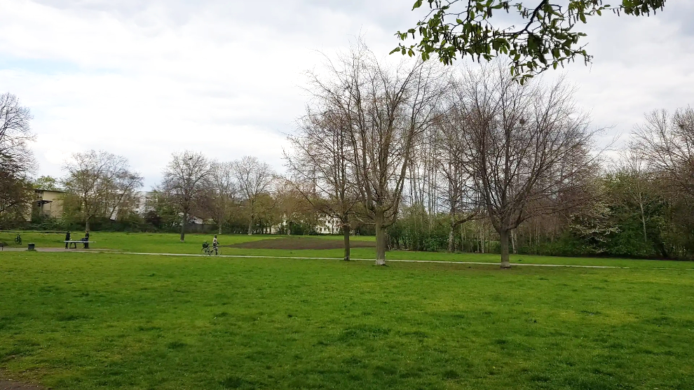 Johannes-Giesberts-Park in Kön-Nippes. Im Hintergrund schiebt eine Person ihr Fahrrad.