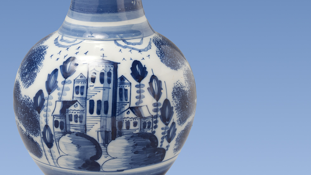 Foto einer blau-weißen Vase vor hellblauem Hintergrund.