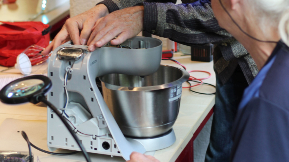 Zwei Senior*innen reparieren eine Küchenmaschine im Repair Café