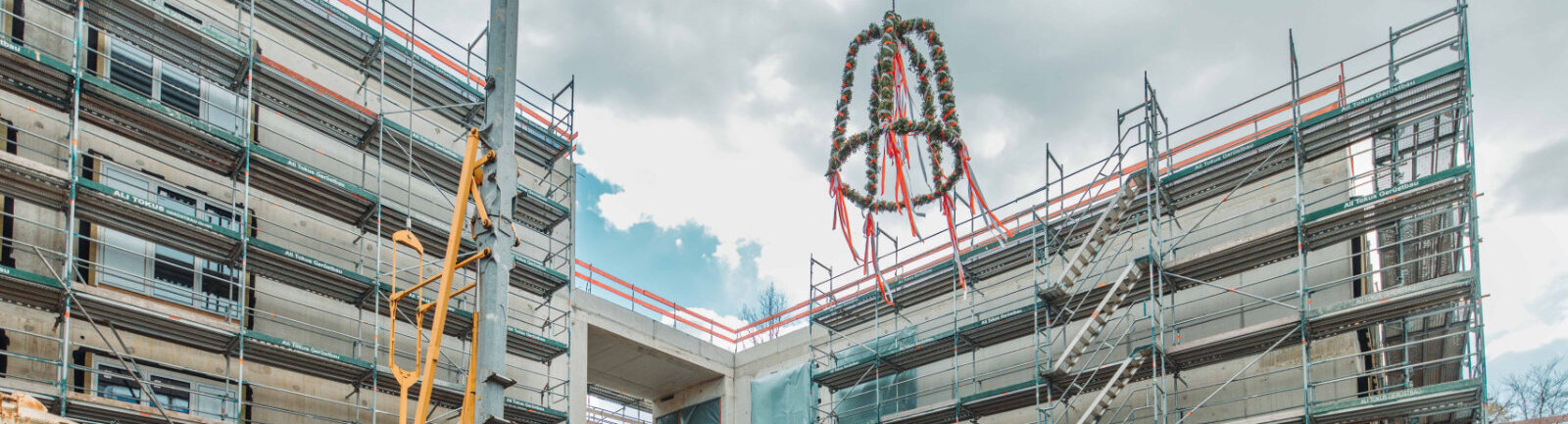 Der Richtkranz wird über dem Rohbau hochgezogen.