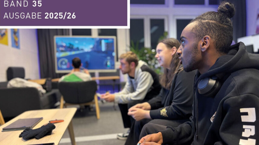 Mehrere junge Menschen sitzen in einem Raum mit Sofas und Stühlen und spielen gemeinsam. Im Vordergrund sitzt eine Person in einem schwarzen Hoodie. Um den Hals hängen große Kopfhörer. Die Person hält einen Controller in den Händen. Weitere Personen sitzen daneben oder dahinter und halten ebenfalls Controller. Im Hintergrund sitzt eine weitere Person vor einem großen Fernseher. Auf dem Bildschirm ist ein Rennspiel zu erkennen.