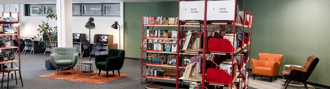 Links an der Wand sieht man Internetplätze, davor zwei Sessel mit Leselampen, daneben ein Bücherregal und rechts im Bild wieder zwei Sessel, © Stadtbibliothek Köln