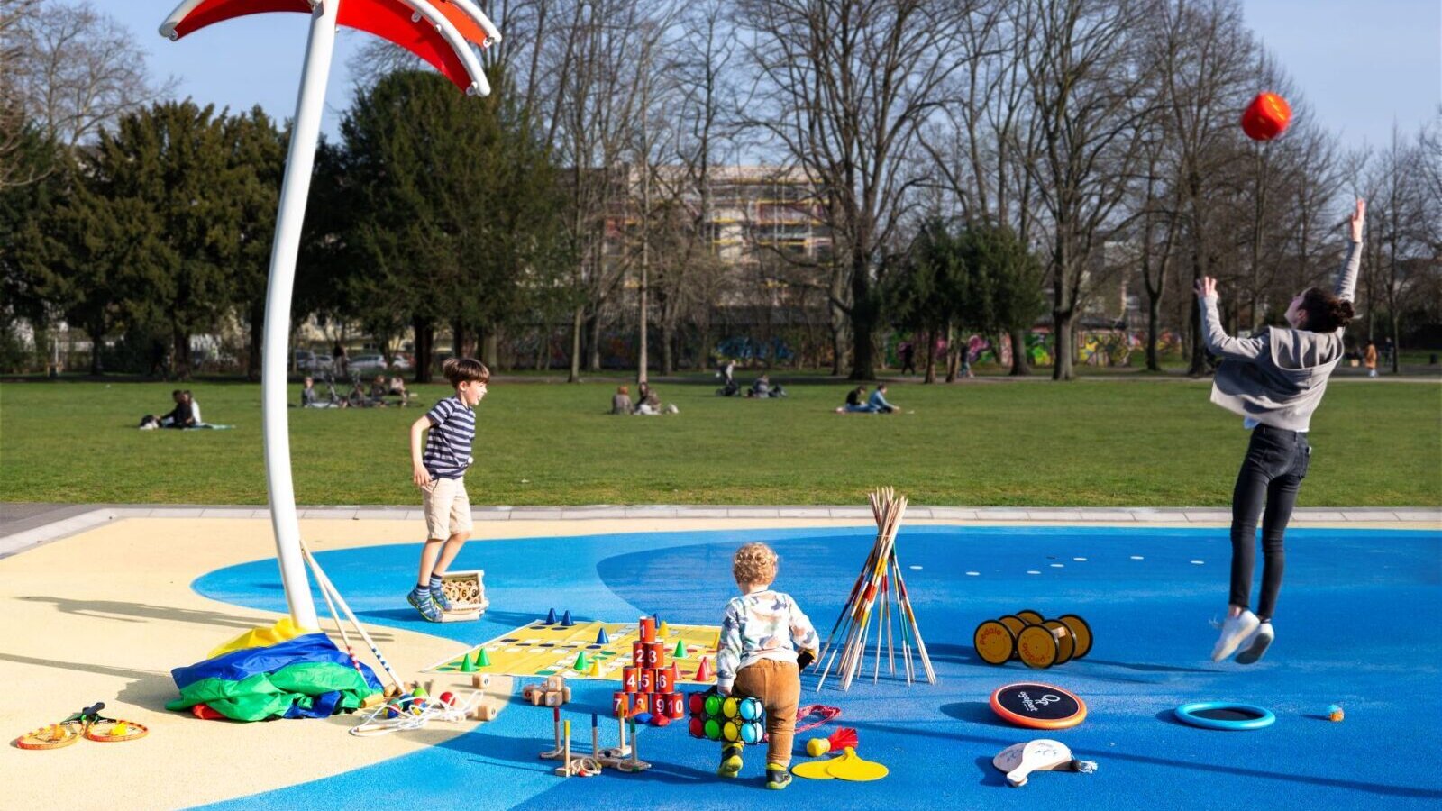 Verschiedene Outdoor-Spiele im Park platziert, zwei Kinder und eine Frau spielen miteinander, © Doerthe Boxberger