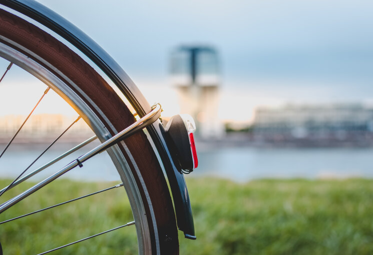 Fahrradrücklicht zum Sonnenuntergang in Köln, © AlexGE Photography – stock.adobe.com