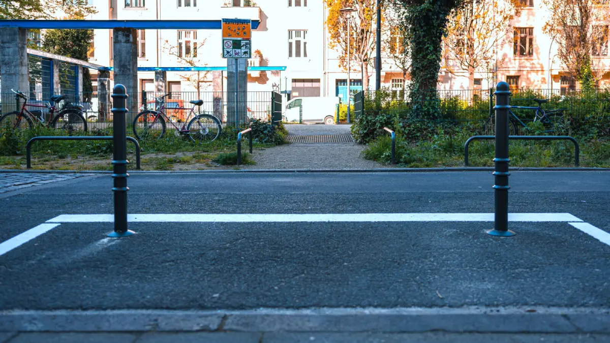 Ansicht einer freien Strecke am Erzberger Platz.  Durch Markierung und Poller wird der Straßenübergang von parkenden Autos  freigehalten.