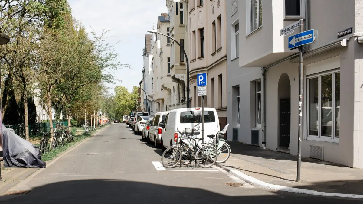 Ansicht einer Freien Ecke am Erzberger Platz. Durch Markierungen und Fahrradständer wird die Straßeneinmündung freigehalten von parkenden Autos.