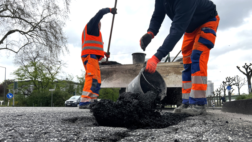 Mitarbeitende des Bauhofs beseitigen ein Schlagloch, © Stadt Köln